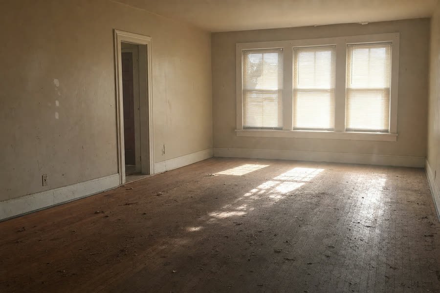 Empty dusty living room with light through closed blinds